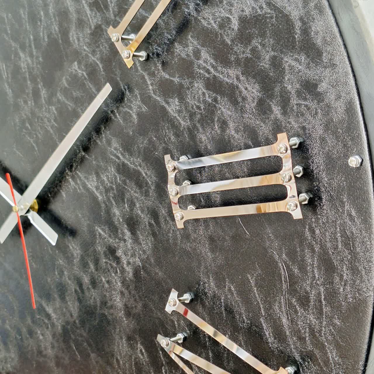 نمای نزدیک ساعت دیواری چرمی مشکی 60 سانتیمتری با اعداد رومی برجسته