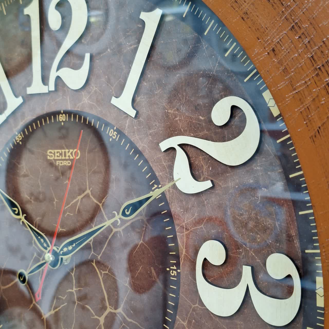 ساعت دیواری قهوه‌ای 60 سانتی‌متری چوبی از نمای نزدیک اعداد دیگر