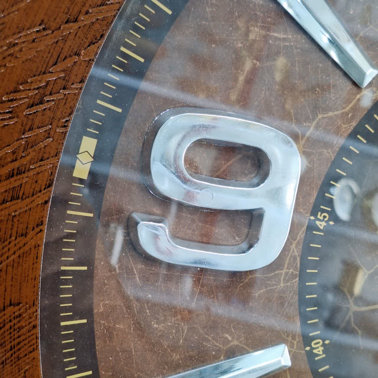 ساعت دیواری قهوه‌ای 60 سانتی‌متری چوبی از نمای نزدیک