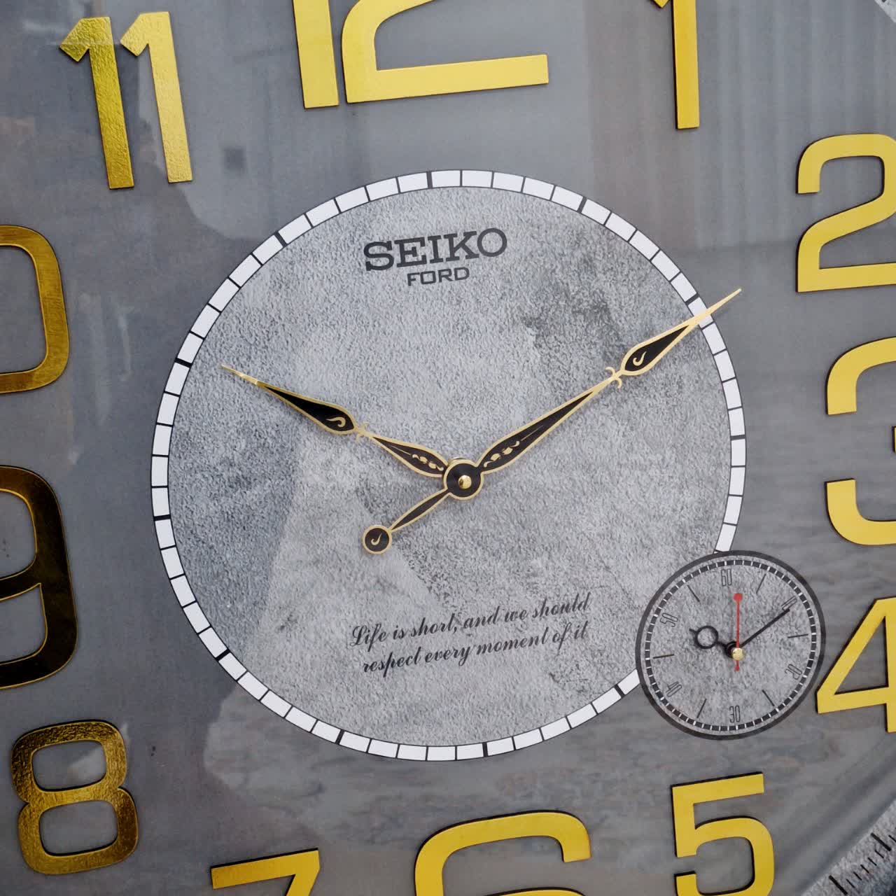 ساعت دیواری طوسی 70 سانتی‌متری چوبی با اعداد کامل طلایی از نمای نزدیک عقربه