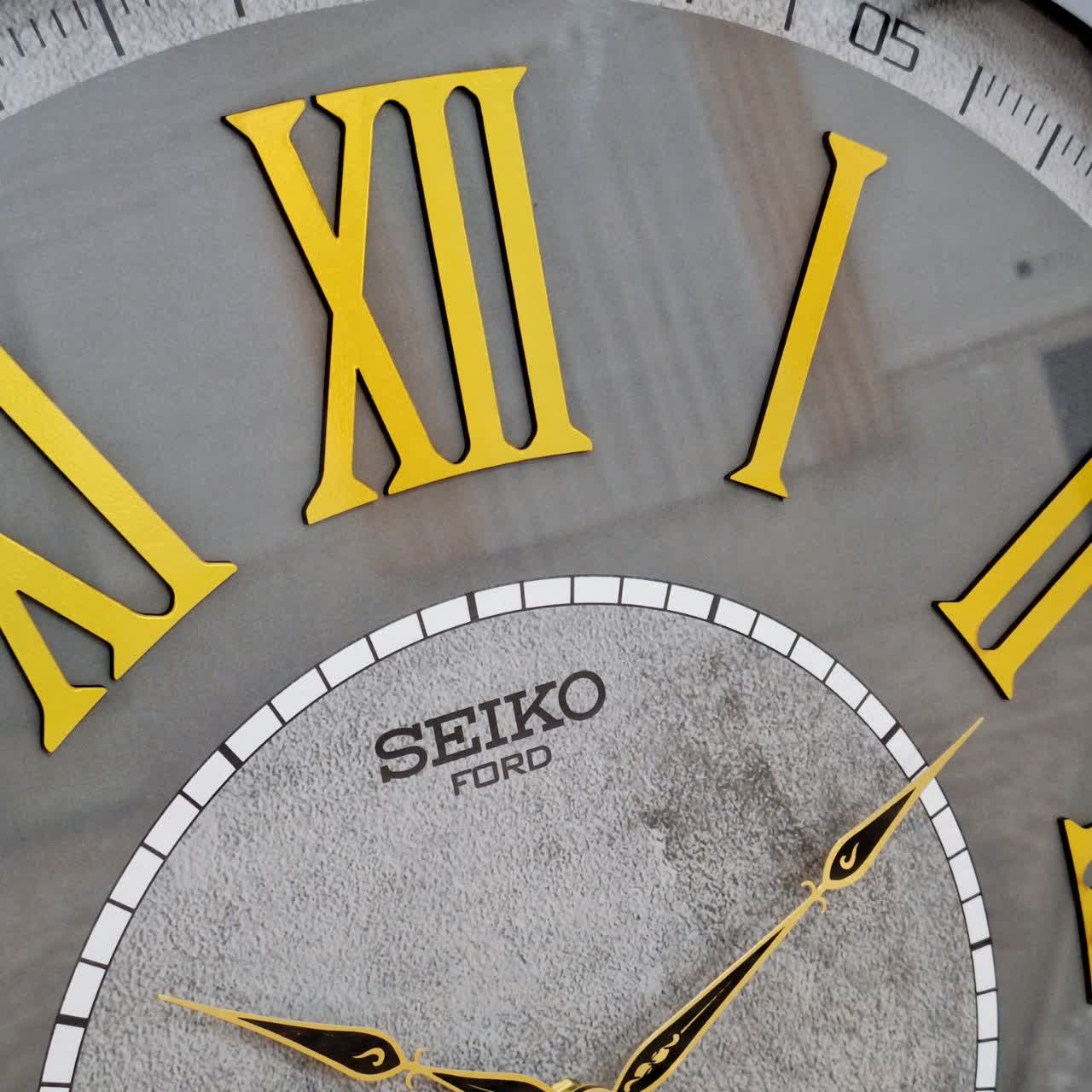 ساعت دیواری طوسی 70 سانتی‌متری چوبی با اعداد رومی از نمای نزدیک عقربه ها