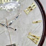 ساعت دیواری قهوهای 50 سانتیمتری فایبر داخل سفید با اعداد رومی طلایی از نمای نزدیک