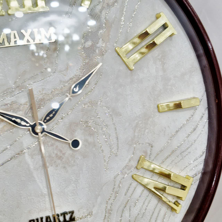 ساعت دیواری قهوهای 50 سانتیمتری فایبر داخل سفید با اعداد رومی طلایی از نمای نزدیک