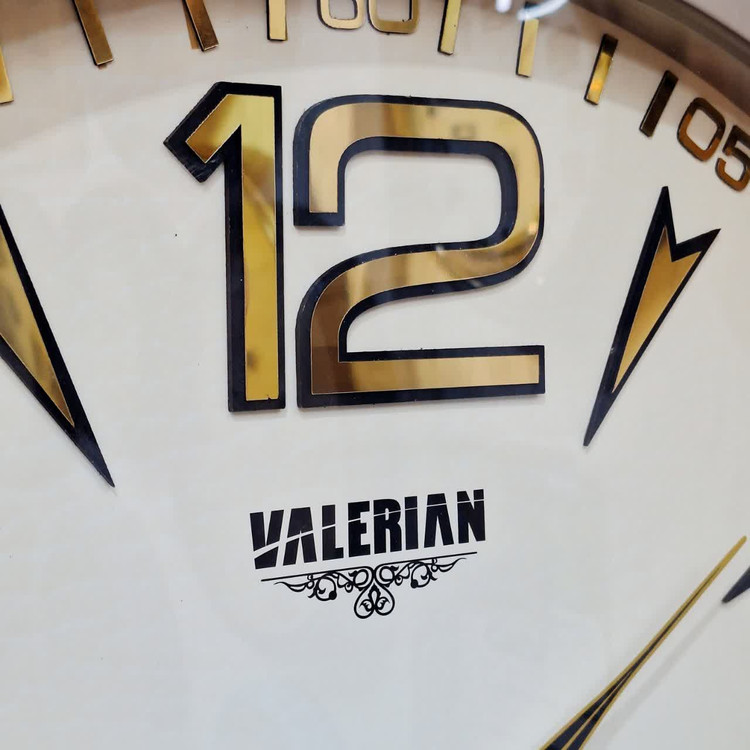 ساعت دیواری بژ 70 سانتیمتری فایبر با اعداد انگلیسی طلایی سه موتوره از نمای نزدیک تر