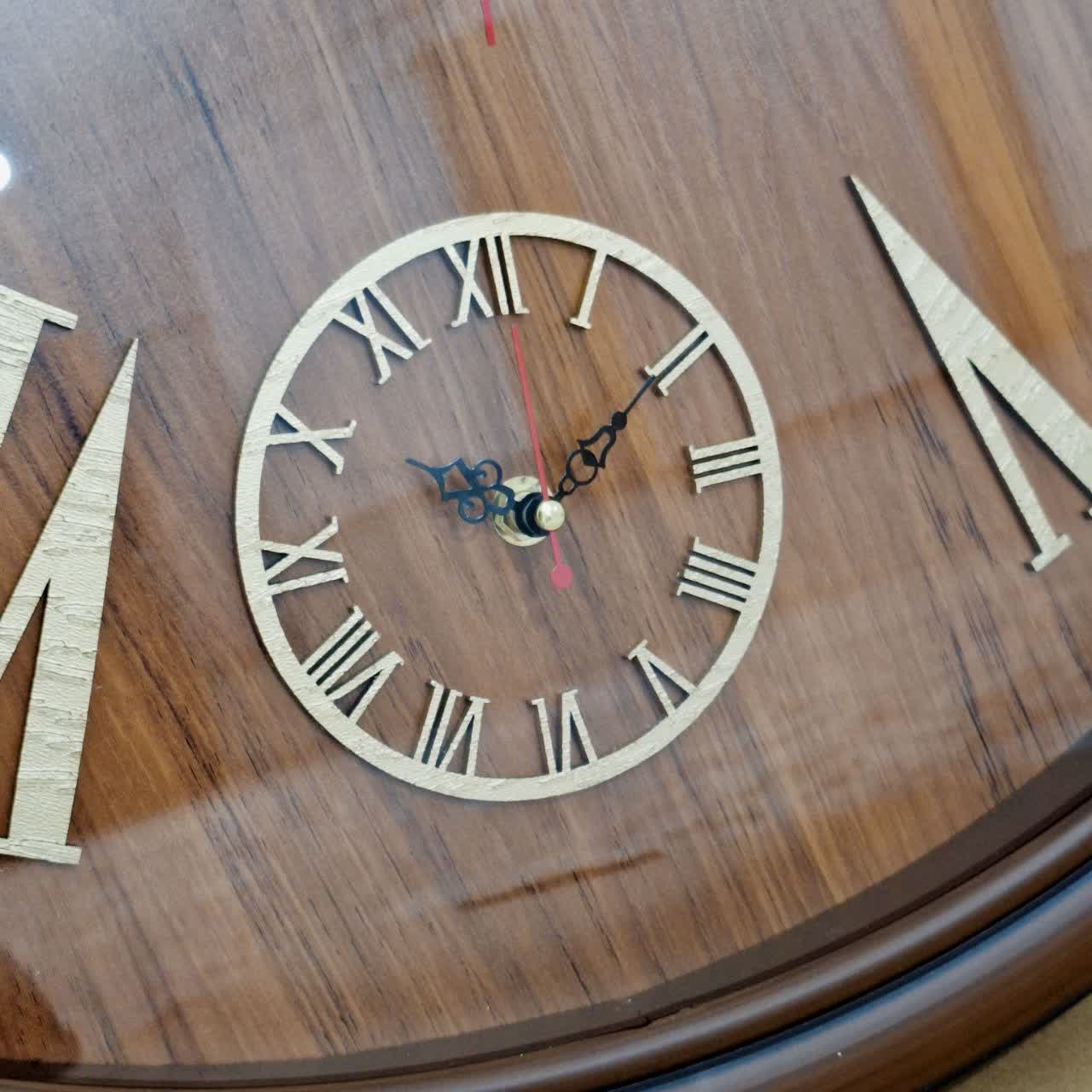 ساعت دیواری قهوه‌ای 65 سانتی‌متری فایبر با اعداد رومی طلایی از نمای نزدیک