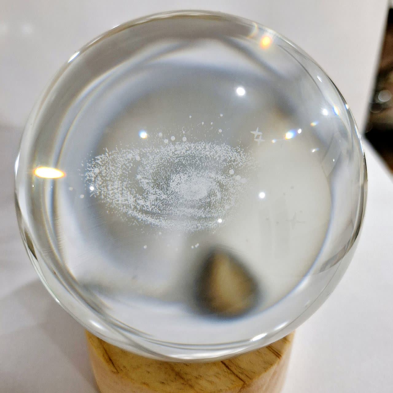 گوی شیشه‌ای مدل کهکشان راه شیری با نور LED رنگی و پایه چوبی از نمای روز