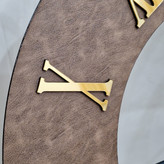 ساعت دیواری چرمی فلزی رینگ مشکی با چرم قهوهای از نمای نزدیک تر