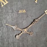 ساعت دیواری چرمی فلزی دو رینگ طلایی با صفحه چرم مشکی از نمای نزدیک