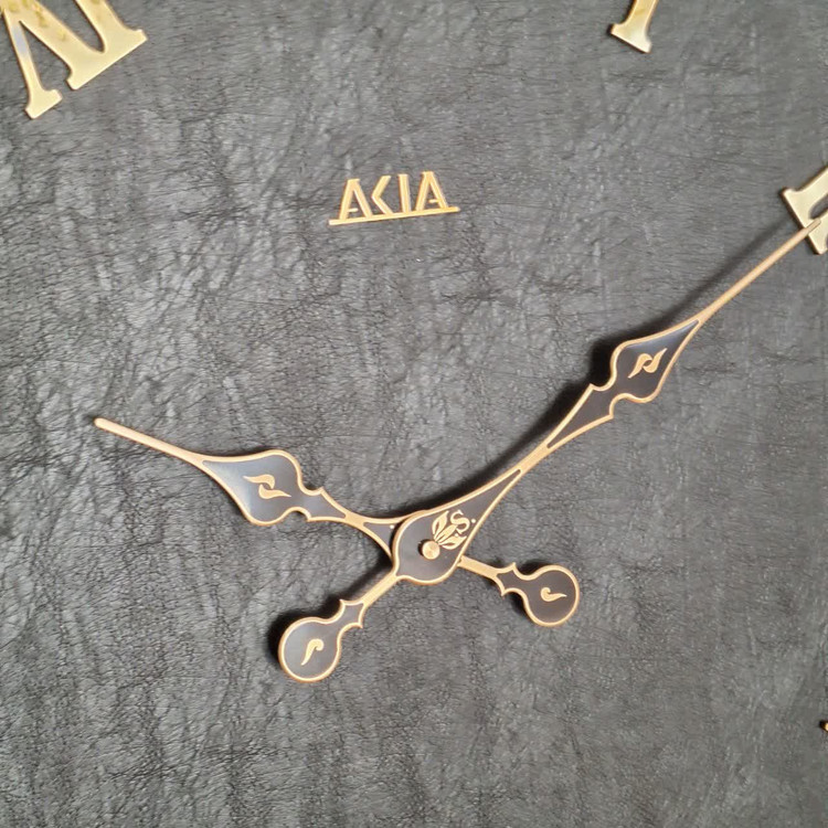 ساعت دیواری چرمی فلزی دو رینگ طلایی با صفحه چرم مشکی از نمای نزدیک