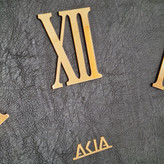 ساعت دیواری چرمی فلزی دو رینگ طلایی با صفحه چرم مشکی از نمای نزدیک بالا