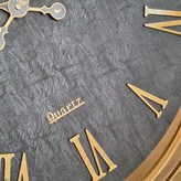 ساعت دیواری چرمی فلزی دو رینگ طلایی با صفحه چرم مشکی از نمای نزدیک پایین