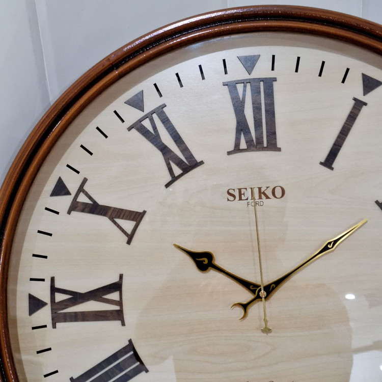 ساعت دیواری گرد سیکو چوبی قهوهای داخل کرم 75 سانتی با اعداد رومی از نمای نزدیک تر