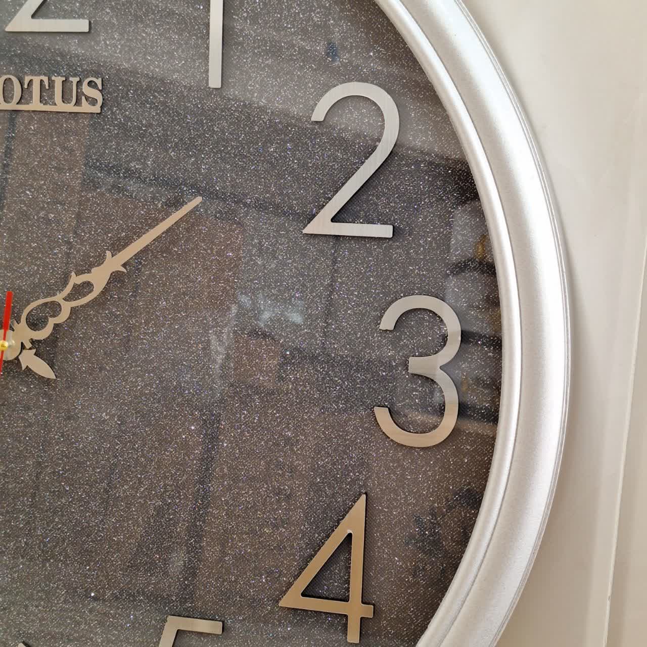 ساعت دیواری گرد ۶۵ سانتی لوتوس فایبر نقرهای داخل شاین با اعداد پلکسی بزرگ سیلور از نمای نزدیک راست