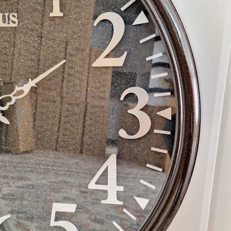 ساعت دیواری گرد ۶۵ سانتی لوتوس فایبر مشکی داخل شاین با اعداد پلکسی بزرگ سیلور از نمای نزدیک راست