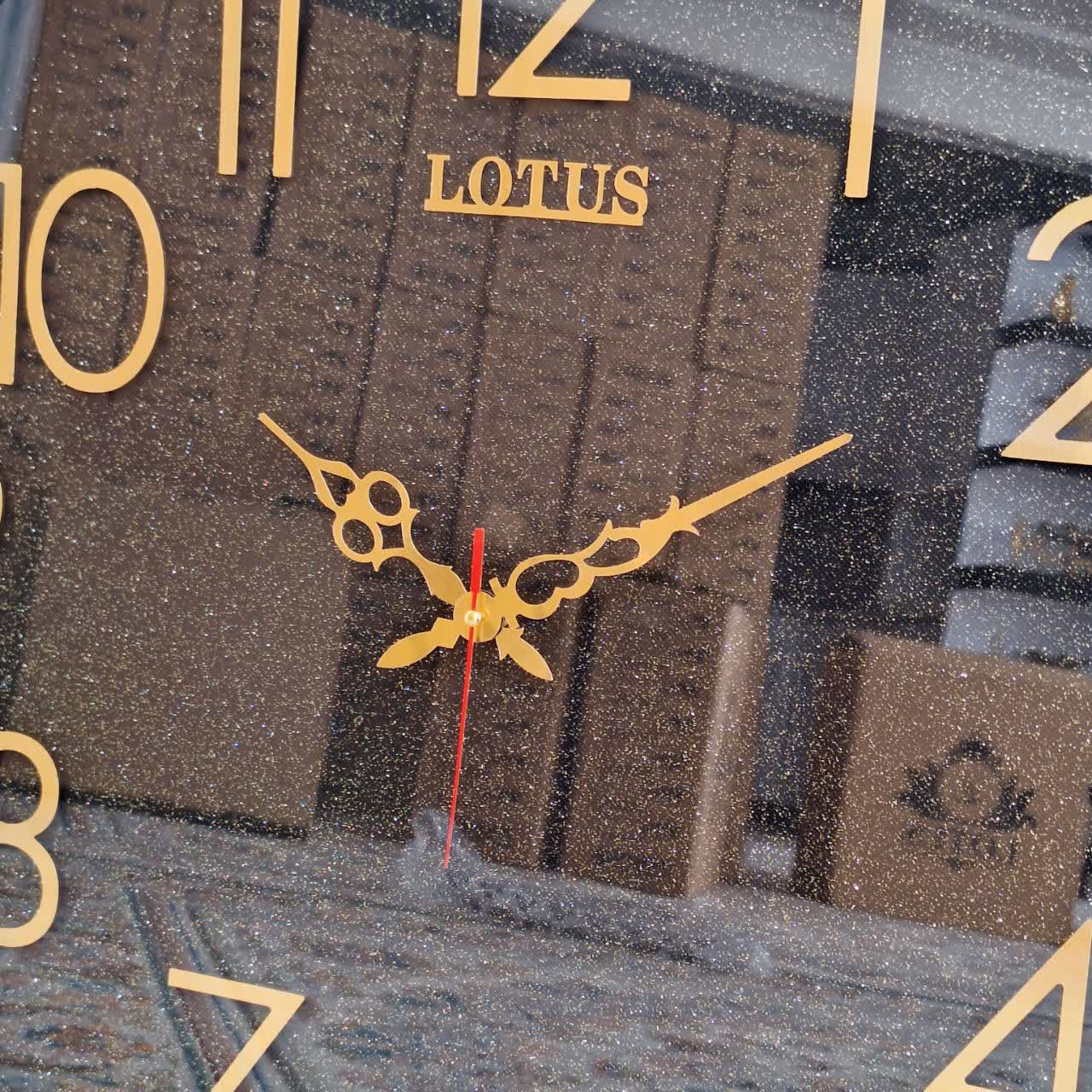 ساعت دیواری گرد ۶۵ سانتی لوتوس فایبر مشکی داخل اکلیلی با اعداد پلکسی بزرگ طلایی از نمای نزدیک