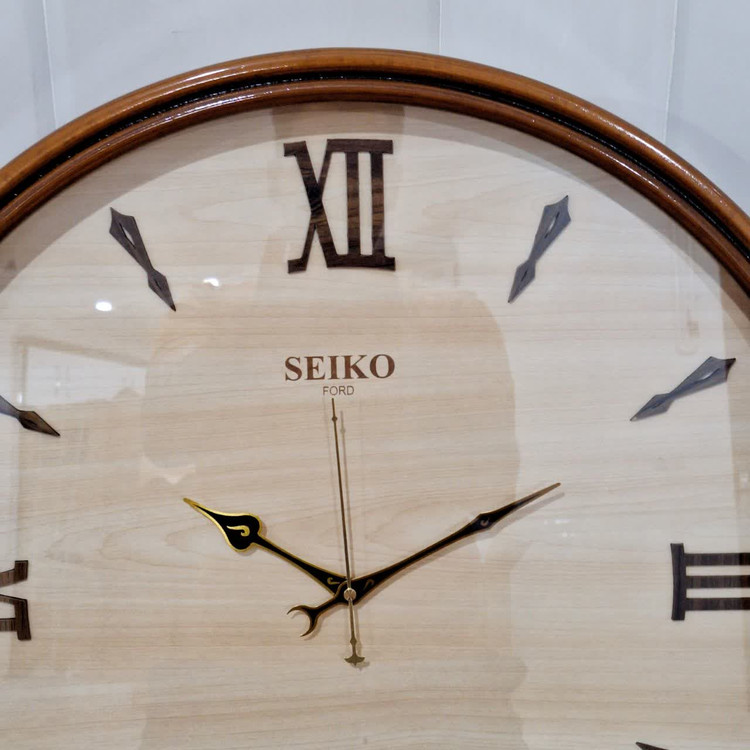 ساعت دیواری گرد ۶۰ سانتی چوبی کرم قهوه ای با اعداد سلطنتی رومی نمای نزدیک تر