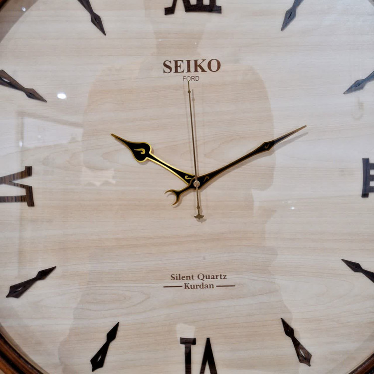 ساعت دیواری گرد ۶۰ سانتی چوبی کرم قهوه ای با اعداد سلطنتی رومی از نمای نزدیک