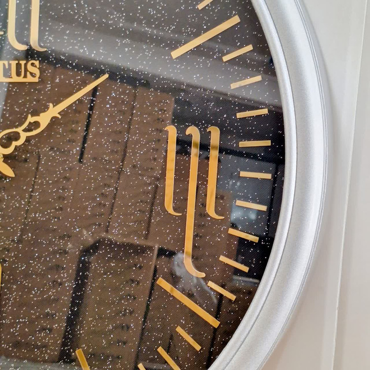 ساعت دیواری گرد ۶۵ سانتی لوتوس فایبر نقرهای داخل مشکی با اعداد پلکسی رومی طلایی نمای نزدیک راست